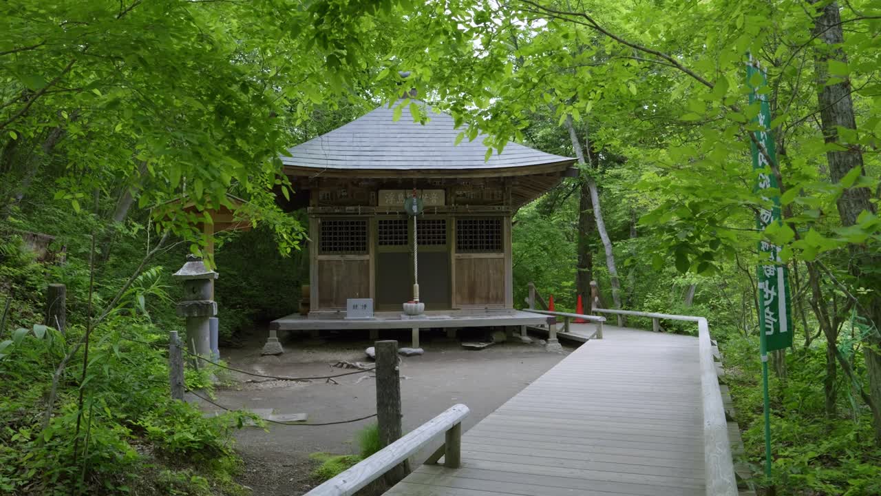 Incredible slow motion cinematic scenery of Japanese shrine building inside forest