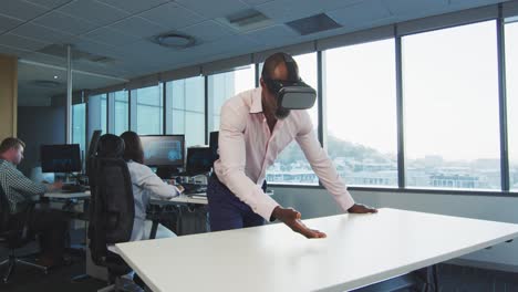 African-American-businessman-wearing-VR-headset-in-modern-office