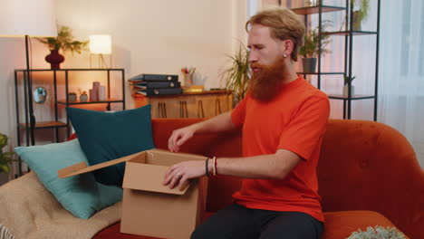 angry dissatisfied shopper man unpacking parcel with dumbbells feeling upset confused wrong delivery