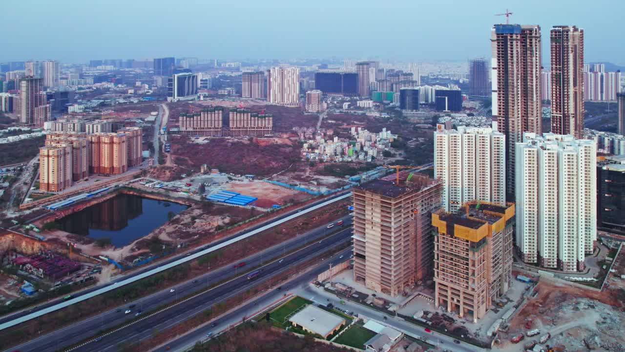 Hyderabad under construction buildings beside nehru outer ring road with vehicles and tallest skyscraper at Kokapet, financial district, telangana, india. day time, pan shot, drone shot, 4k.