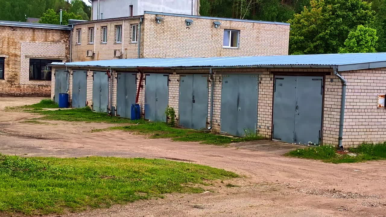 Row of brick garages with closed metal doors in industrial area courtyard