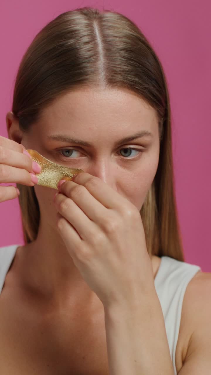 mujer aplicando parches de oro en la cara