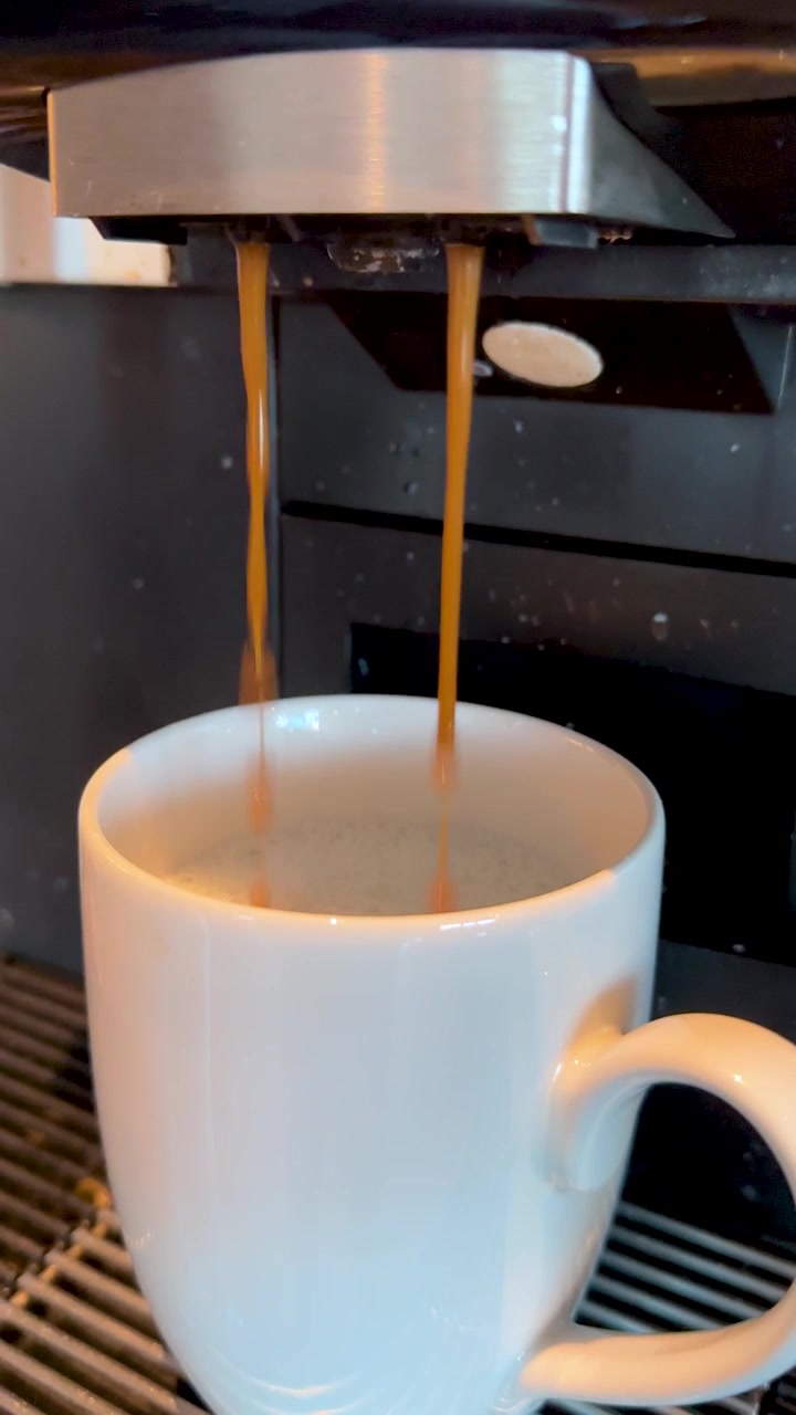 Café Expresso Sendo Derramado em uma Caneca Branca de uma Máquina Automática
