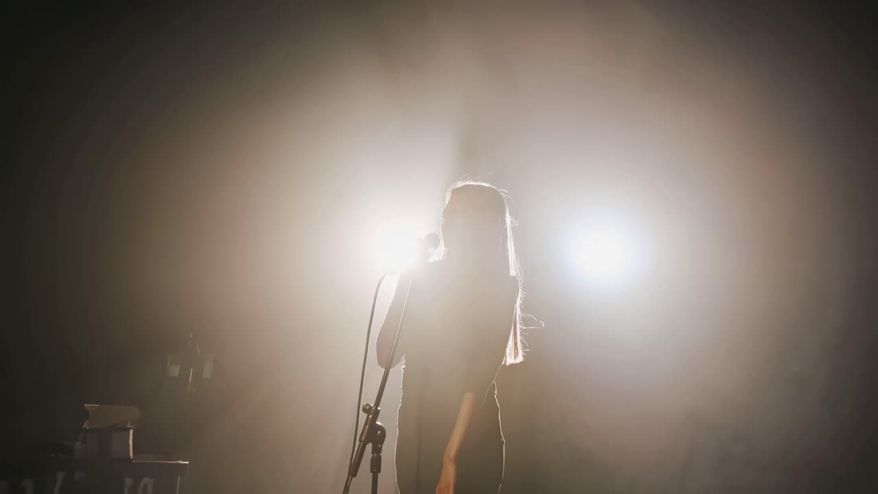 Close-up side angle of a singer passionately performing on stage, captured in a cinematic video