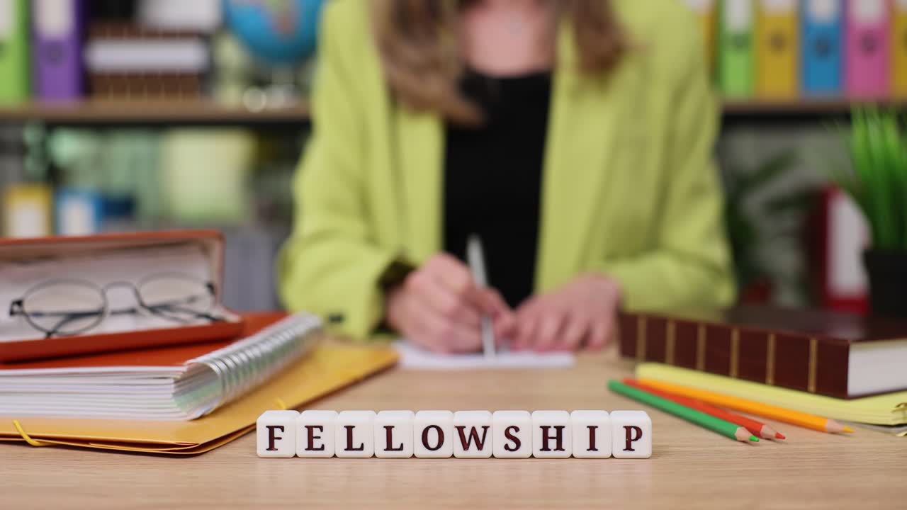 Fellowship Concept with Woman Writing at Desk