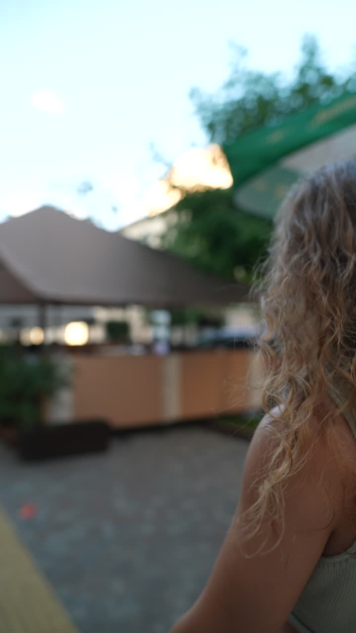 mujer con cabello rizado en una calle de la ciudad