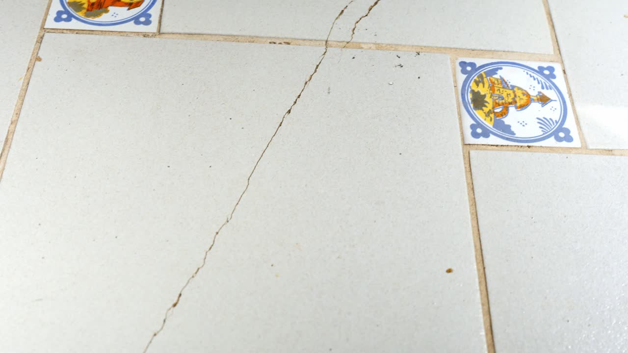 en la vista vieja azulejos blancos agrietados en forma cuadrada, piso de azulejos agrietado