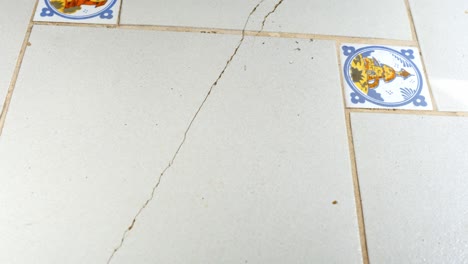 view at old cracked white tiles in square shape, tile floor cracking