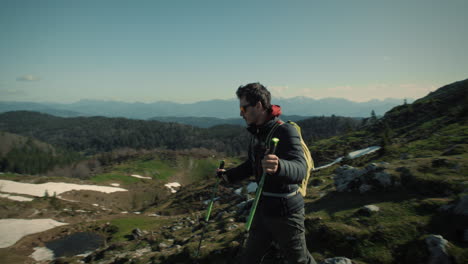 HIker-walking-on-the-path-wearing-warm-jacket-and-a-backpack