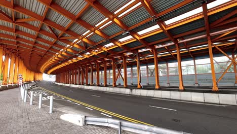 orange metal tunnel in hong kong with some traffic and pedestrians; time lapse