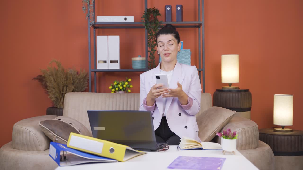 la mujer que trabaja desde casa disfruta de aplicaciones móviles en el teléfono.