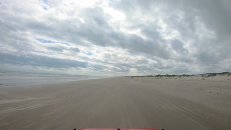 Pov-Durch-Die-Heckscheibe-Des-Fahrzeugs-Am-Strand-Zwischen-Brandung-Und-Dünen-An-Der-North-Padre-Island-National-Seashore-In-Der-Nähe-Von-Corpus-Christi-Texas-USA-An-Einem-Bewölkten-Tag