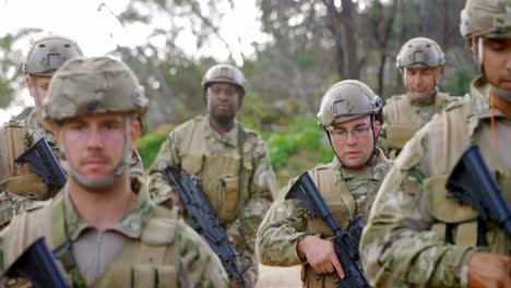 Vista-Frontal-De-Soldados-Militares-De-Raza-Mixta-Entrenando-Con-Rifles-En-Campos-Durante-El-Entrenamiento-Militar-4k