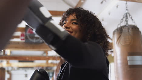 Entrenador-De-Boxeo-Masculino-Con-Boxeadora-En-El-Gimnasio-Usando-Guantes-De-Entrenamiento