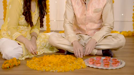 una pareja india haciendo rangoli.