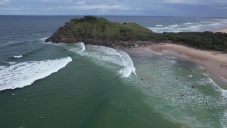 surfers at cabarita beach near norries headland and cove in new south wales, australia