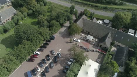 aerial of wedding car arriving with the guests waiting and applauding