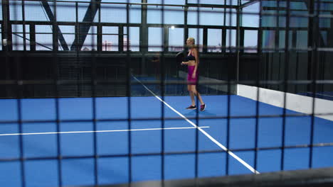 women playing padel tennis on indoor court, focusing on competitive match