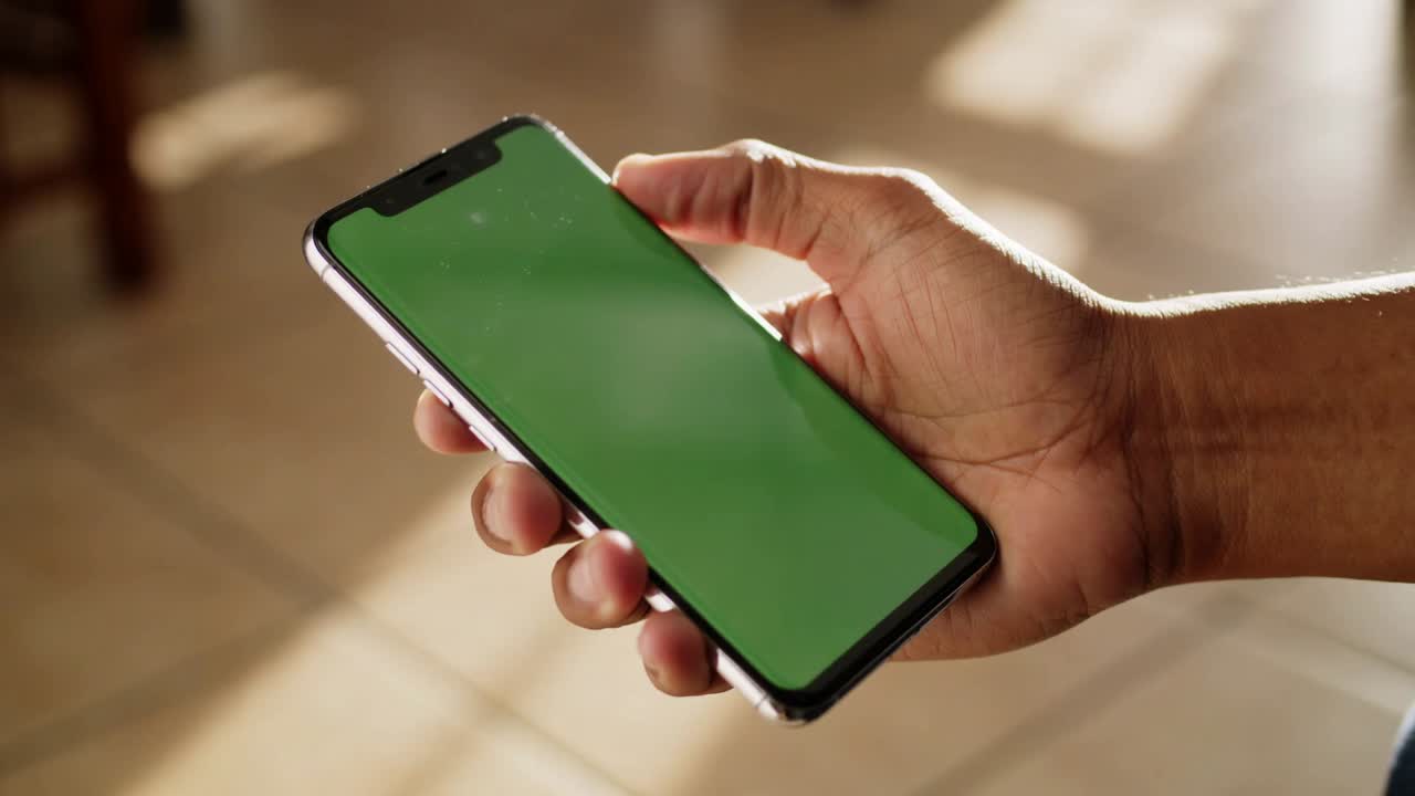 Mano che tiene uno smartphone con uno schermo verde