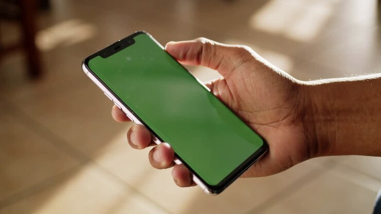Mano che tiene uno smartphone con uno schermo verde