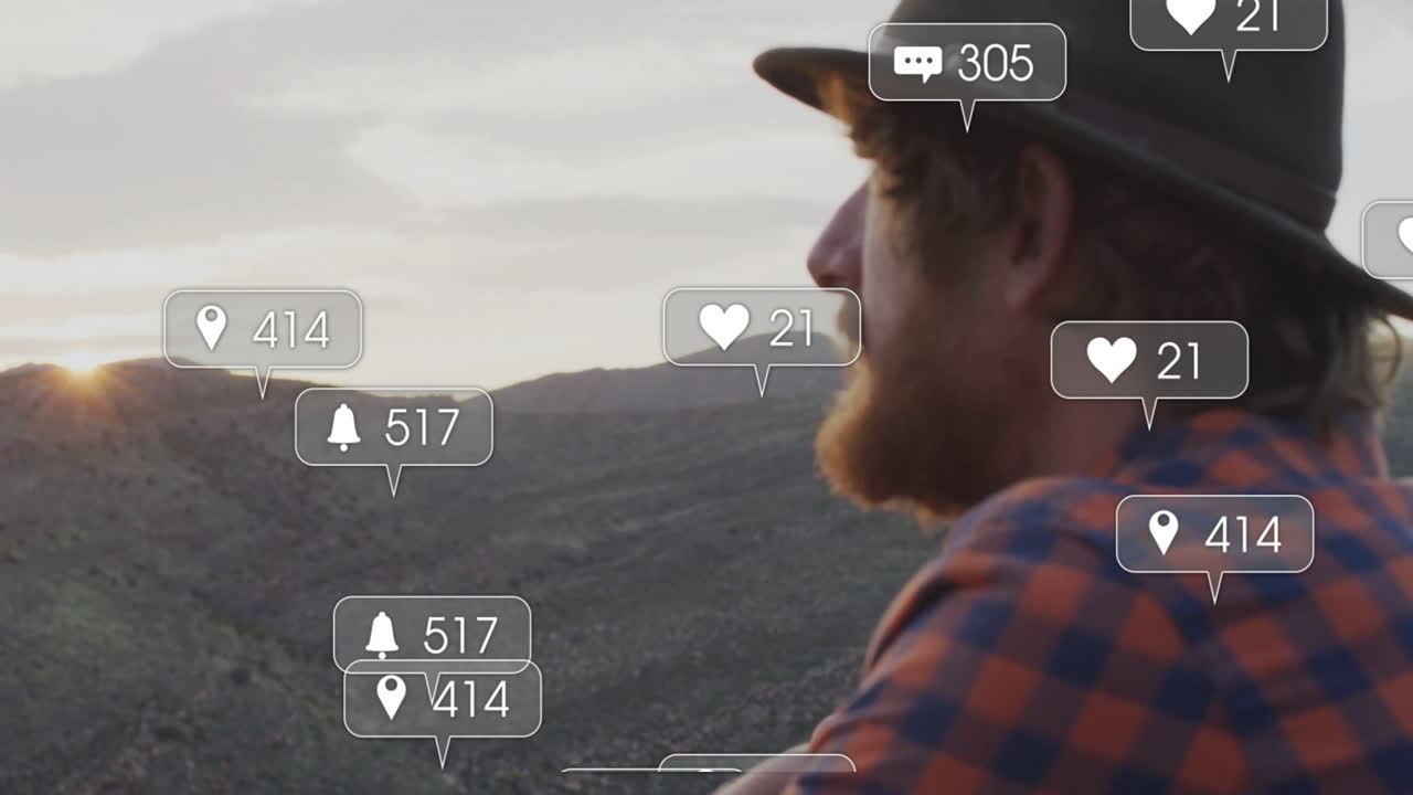Man sitting on rocky hillside at sunset, with floating social media marketing notification icons
