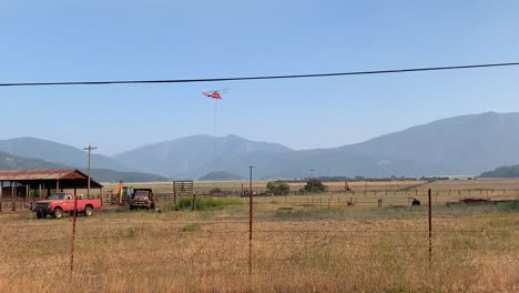 helicóptero de bomberos sobrevolando tierras de cultivo