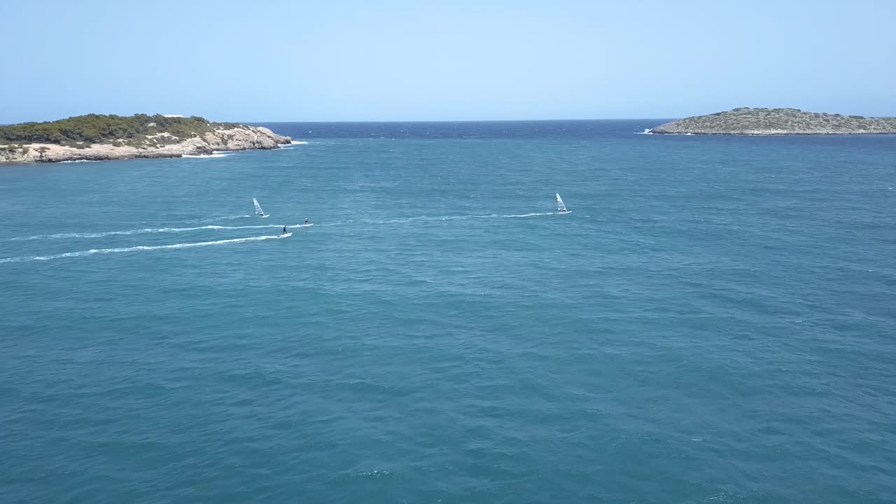 Parallax Drone View of Four WindSurf and Eboard Riders in the North of Ibiza on Turquoise Waters