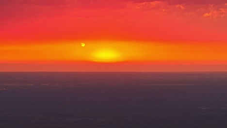 sunset over ocean horizon with vibrant orange sky and soft glowing clouds