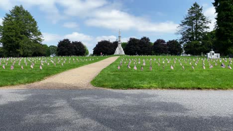 Gettysburg-National-Cemetery,-site-of-Civil-War-military-veterans,-American-flags-blow-in-wind-on-summer-day