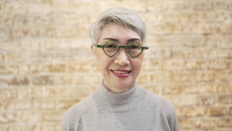successful mature senior business woman looking at camera with pride and smile on face