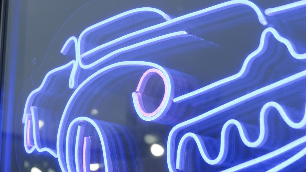 el coche en la gasolinera es un letrero azul neón.