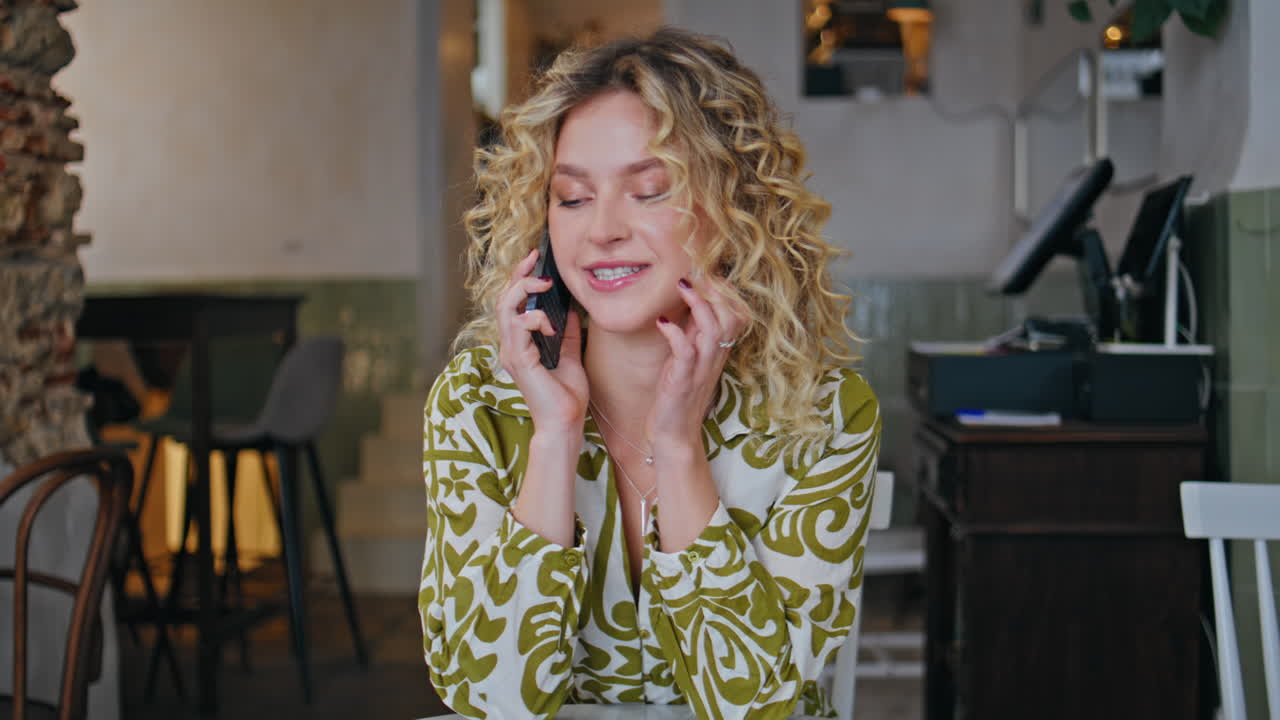 Smiling woman talking cellphone sitting table small cafe closeup. Lady calling