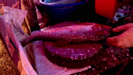 sequence of preparing fish at a market stall