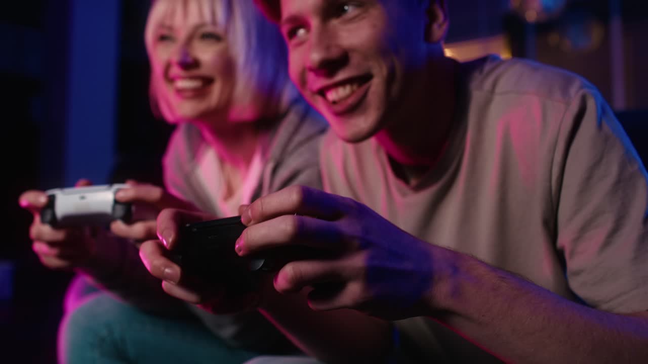 Detail of young caucasian couple playing video game with game pad