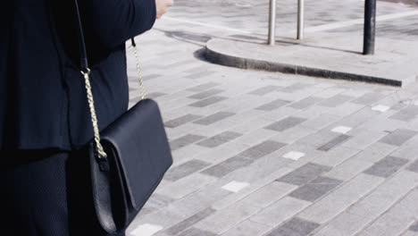 Attractive-business-woman-commuter-using-smartphone-walking-in-city-of-london