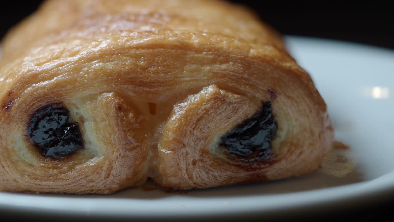 Primo piano di un delizioso pain au chocolat su un piatto bianco