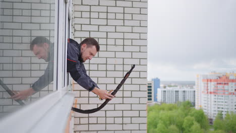 a man at high altitude installs air conditioning. replacement of thermal insulation. air conditioning systems