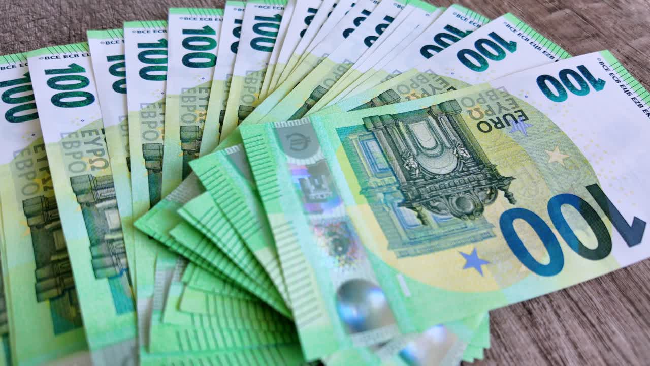 펼쳐진 유로 지폐가 테이블 위에 펼쳐져 있습니다.