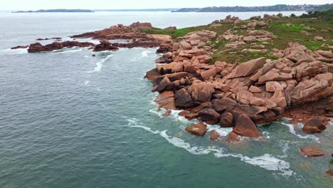 approaching drone movement to the popular pink granite coastaka aka côte de granit rose rocky shoreline landscape, ploumanac'h, brittany, france