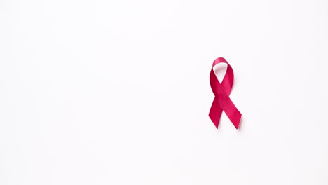 detail of male hand putting ribbon in red color on white background