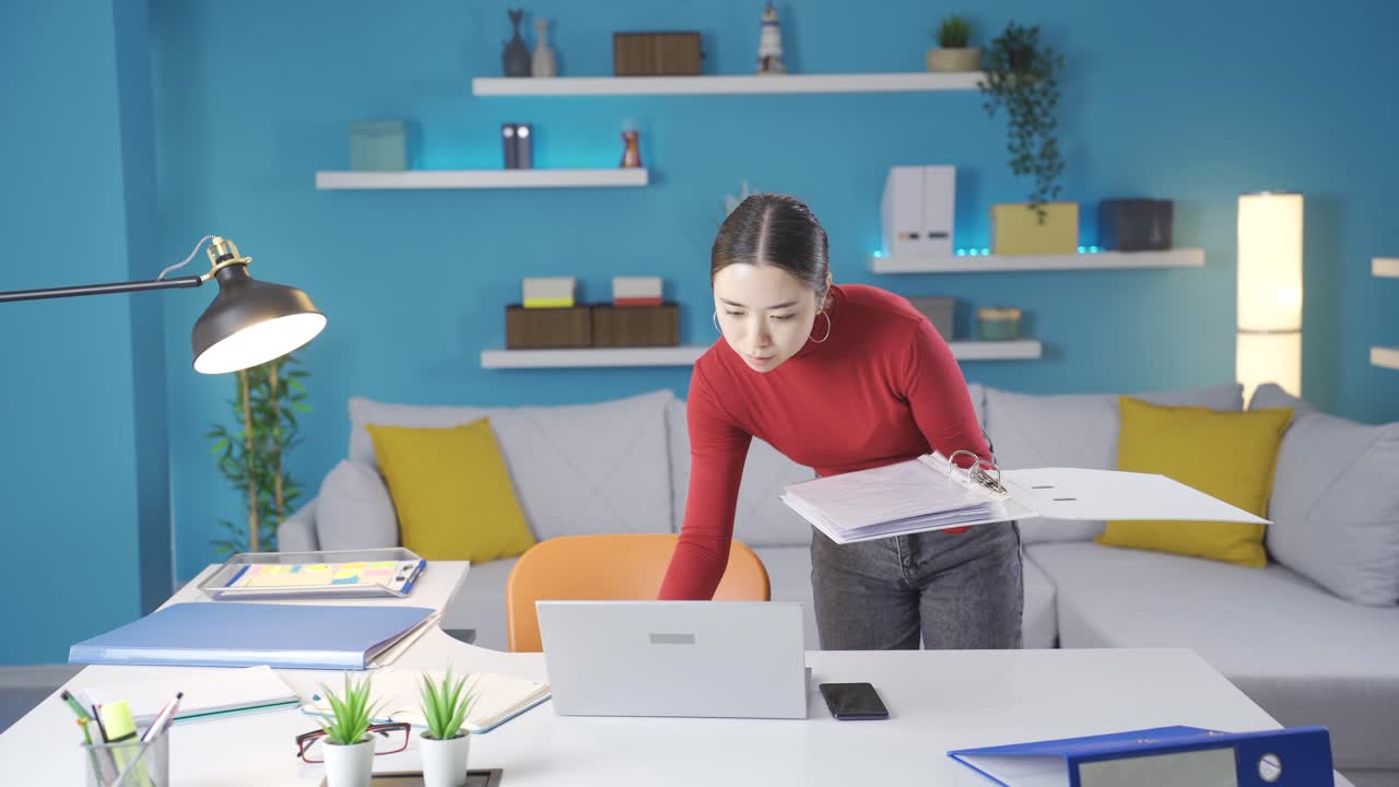 집에서 파일을 확인하는 아시아 여성은 노트북에서 보는 것이 일치하지 않을 때 화가 납니다.