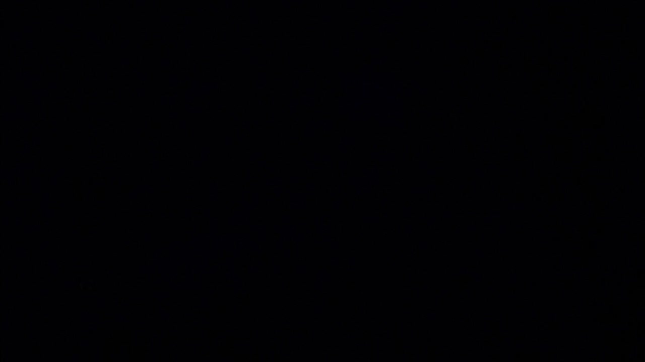 SLOW MOTION: Inside a creepy haunted house during Halloween with black lights and strobes, mannequins, skulls, clowns, evil rabbits, and spooky designs