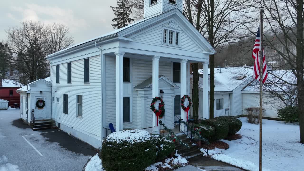 눈 덮힌 날에 크리스마스를 위해 장식된 작은 교회의 상승 공중