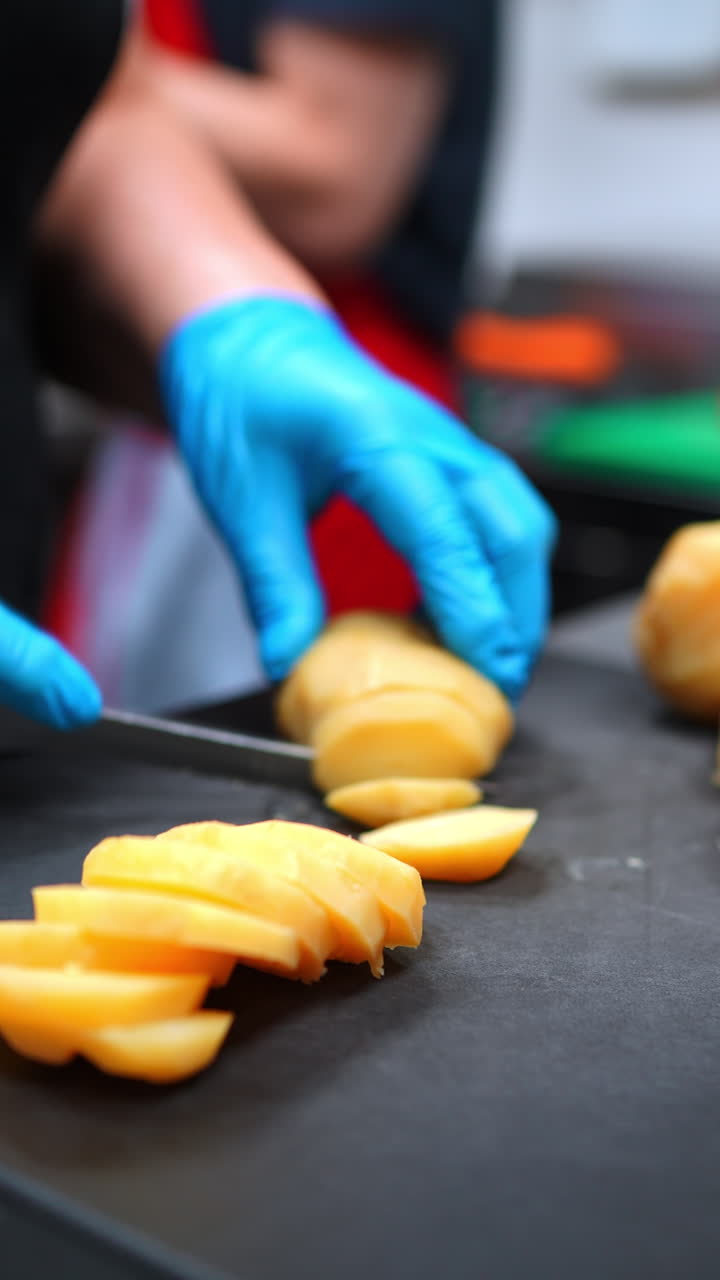 Chef preparing sliced potatoes