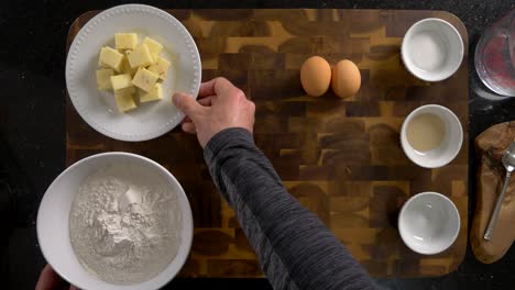 showing bread baking ingredients from an overhead view. including flour, sugar, yeast, salt, eggs and water