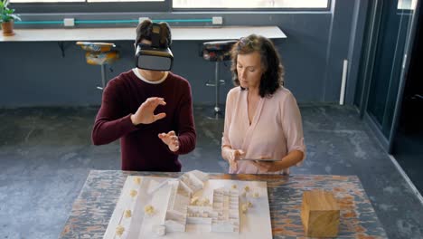 executives using digital tablet and virtual reality headset while discussing over architectural mode