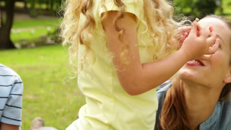 Cute-girl-putting-flower-behind-her-mothers-ear