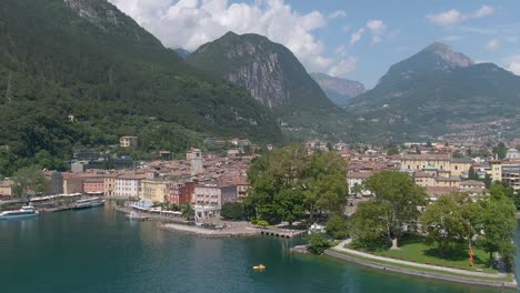 beautiful drone view of the north italian city riva del garda with the lake garda in the foreground and the alps in the background