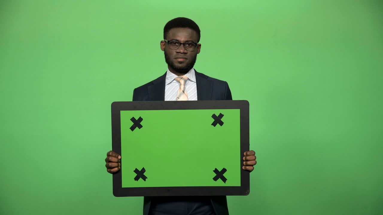 молодой африканский мужчина, держащий доску chromakey