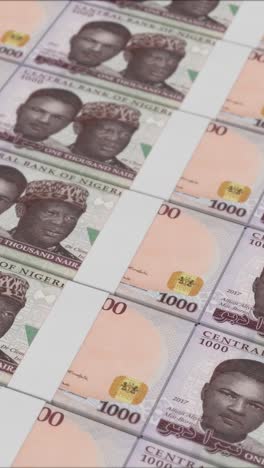 vertical video of 1000 nigerian naira banknotes printed by a money press